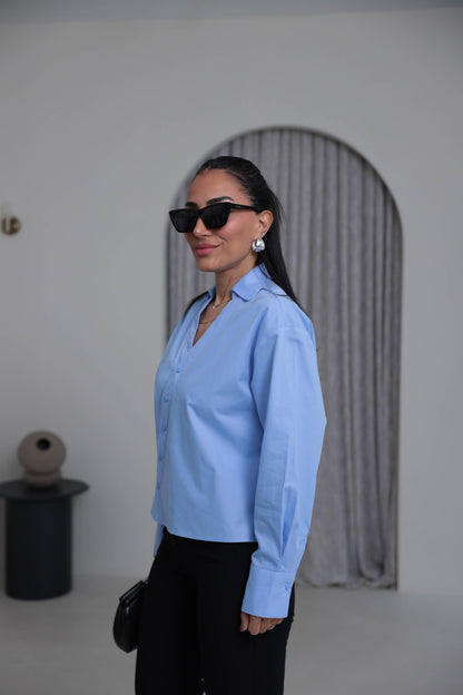 Two-piece shirt (wrappable like a skirt) in blue poplin fabric with an elegant design