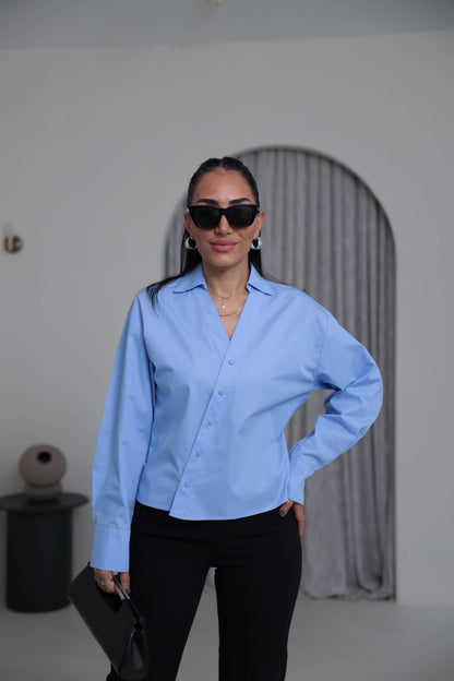 Two-piece shirt (wrappable like a skirt) in blue poplin fabric with an elegant design