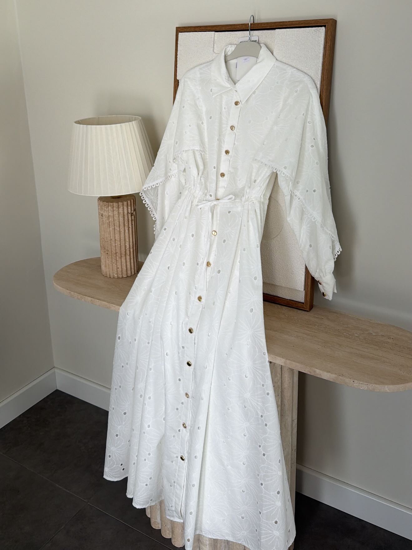 Belted openwork embroidery with gold buttons