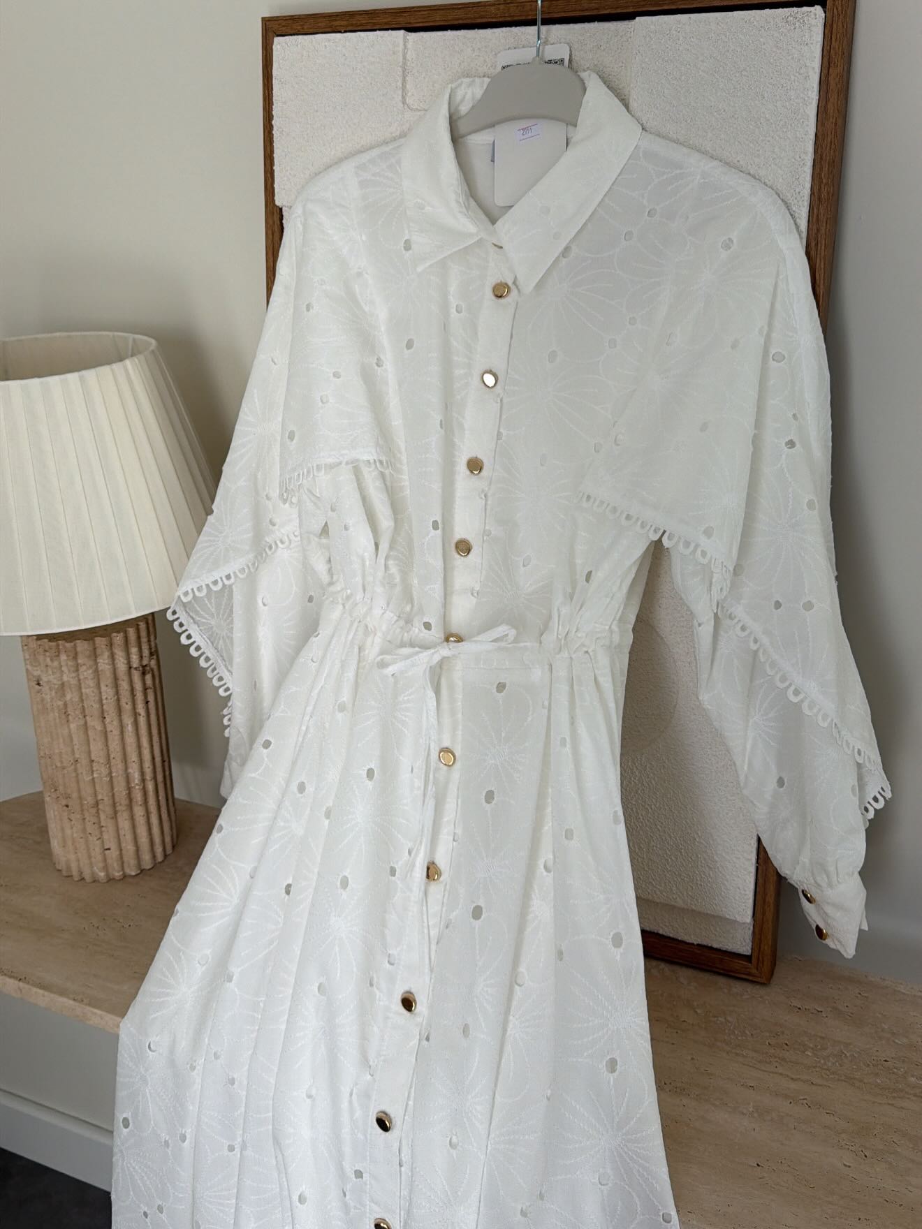 Belted openwork embroidery with gold buttons
